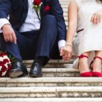 38163405 - unrecognizable young wedding couple holding hands as they enjoy romantic moments outside on the stairs